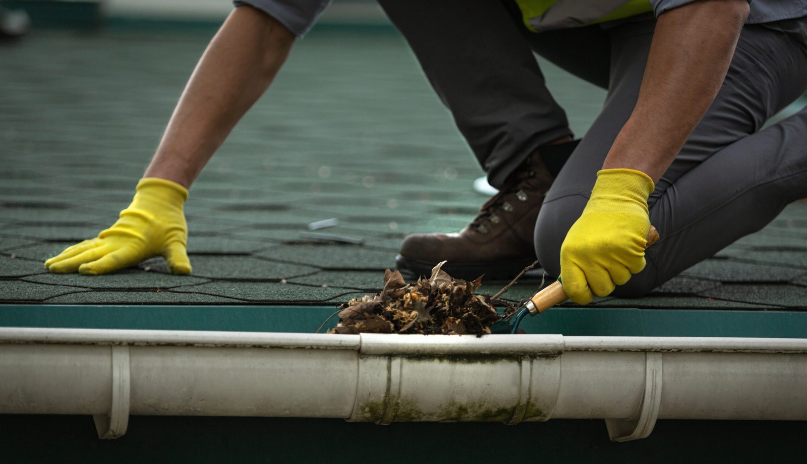 man cleaning out a gutter